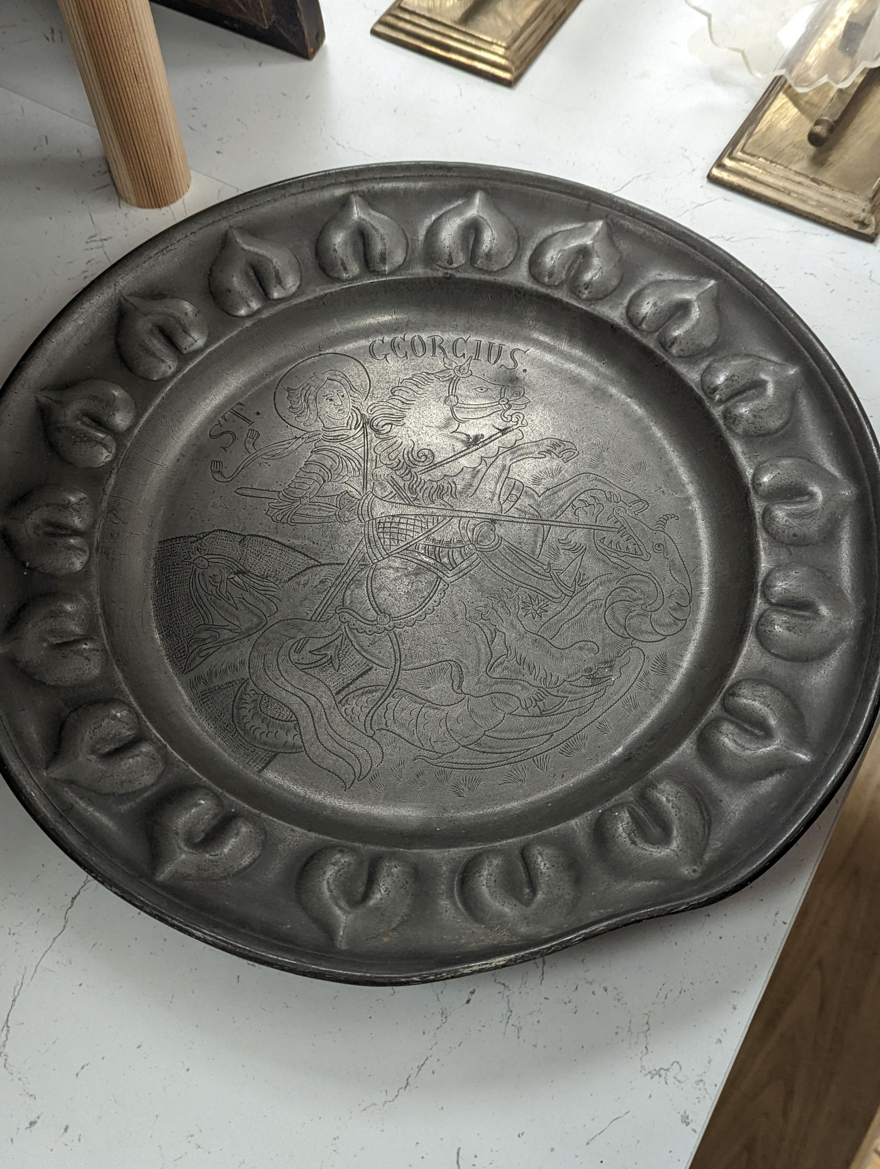 A near pair of Salzburg pewter wrigglework chargers, diameter 41cm, and six similar plates, 18th/19th century